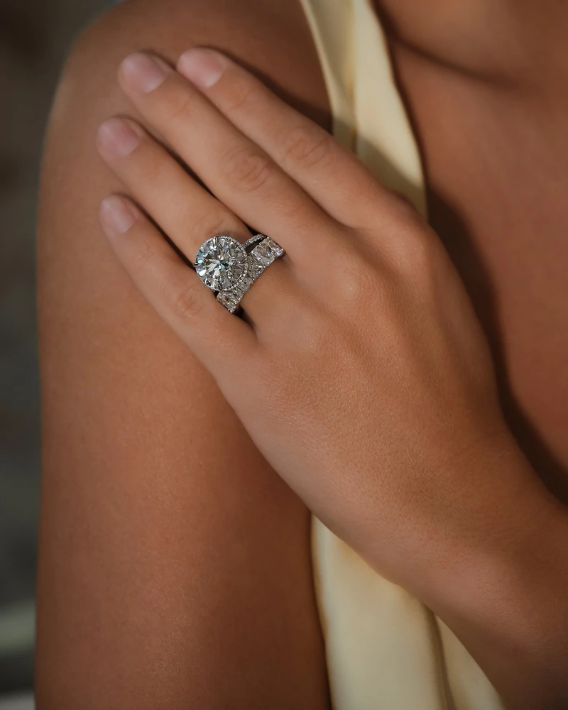Hand resting on a shoulder, wearing a ring with two large stones